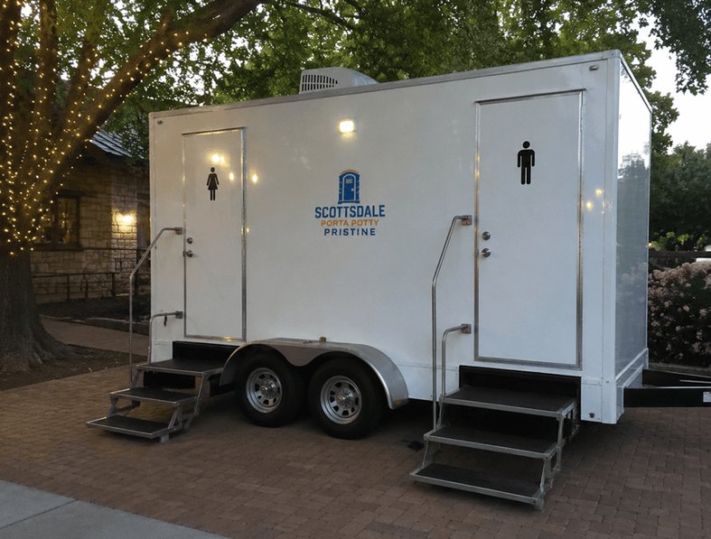 Two-station luxury restroom trailer rental lit up at an evening wedding venue